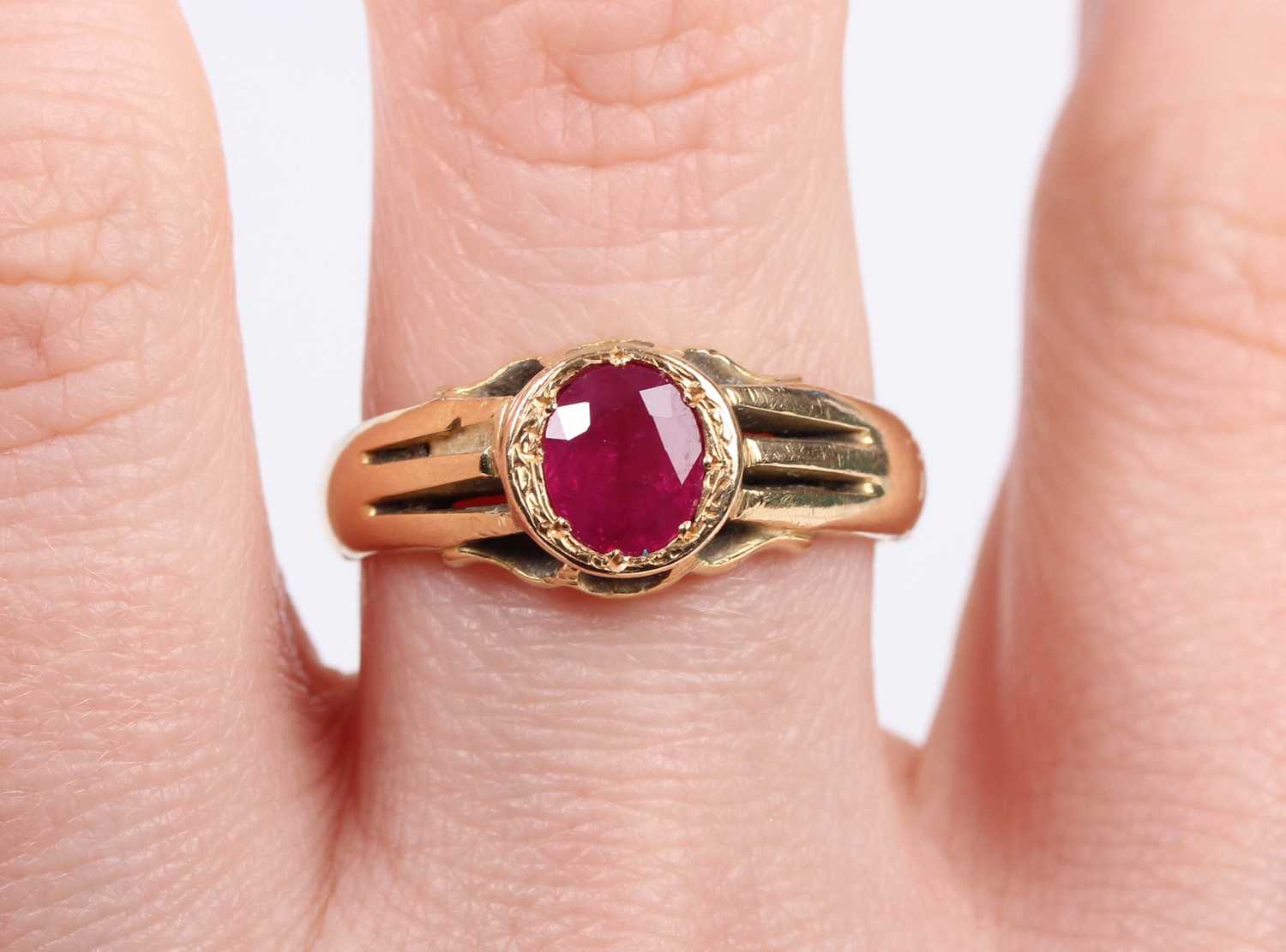 A gold ring, mounted with an oval cut treated ruby, detailed ‘18ct’, weight 6.4g, ruby weight approx - Image 5 of 5