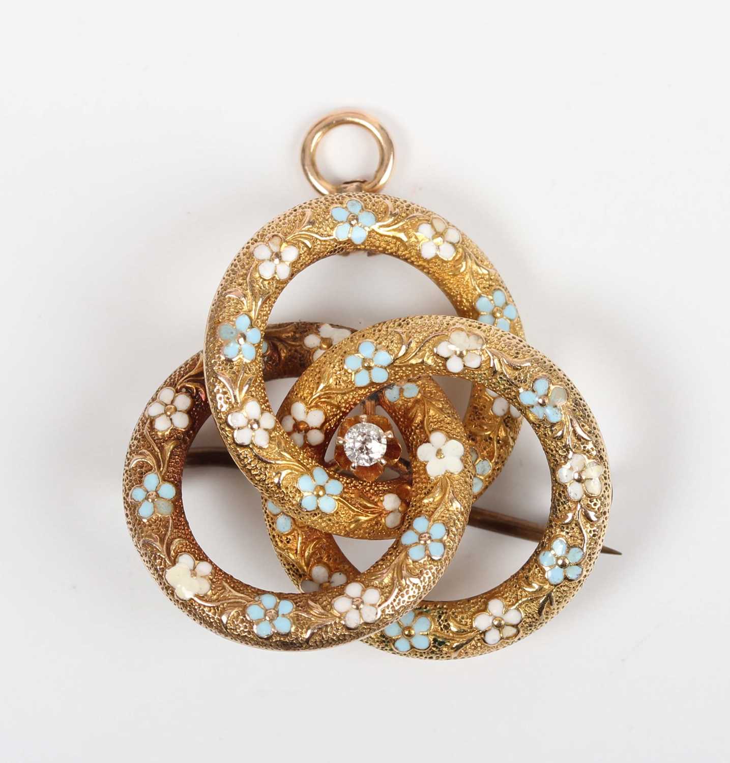 A gold, diamond and enamelled pendant brooch in an entwined trefoil design, claw set with a