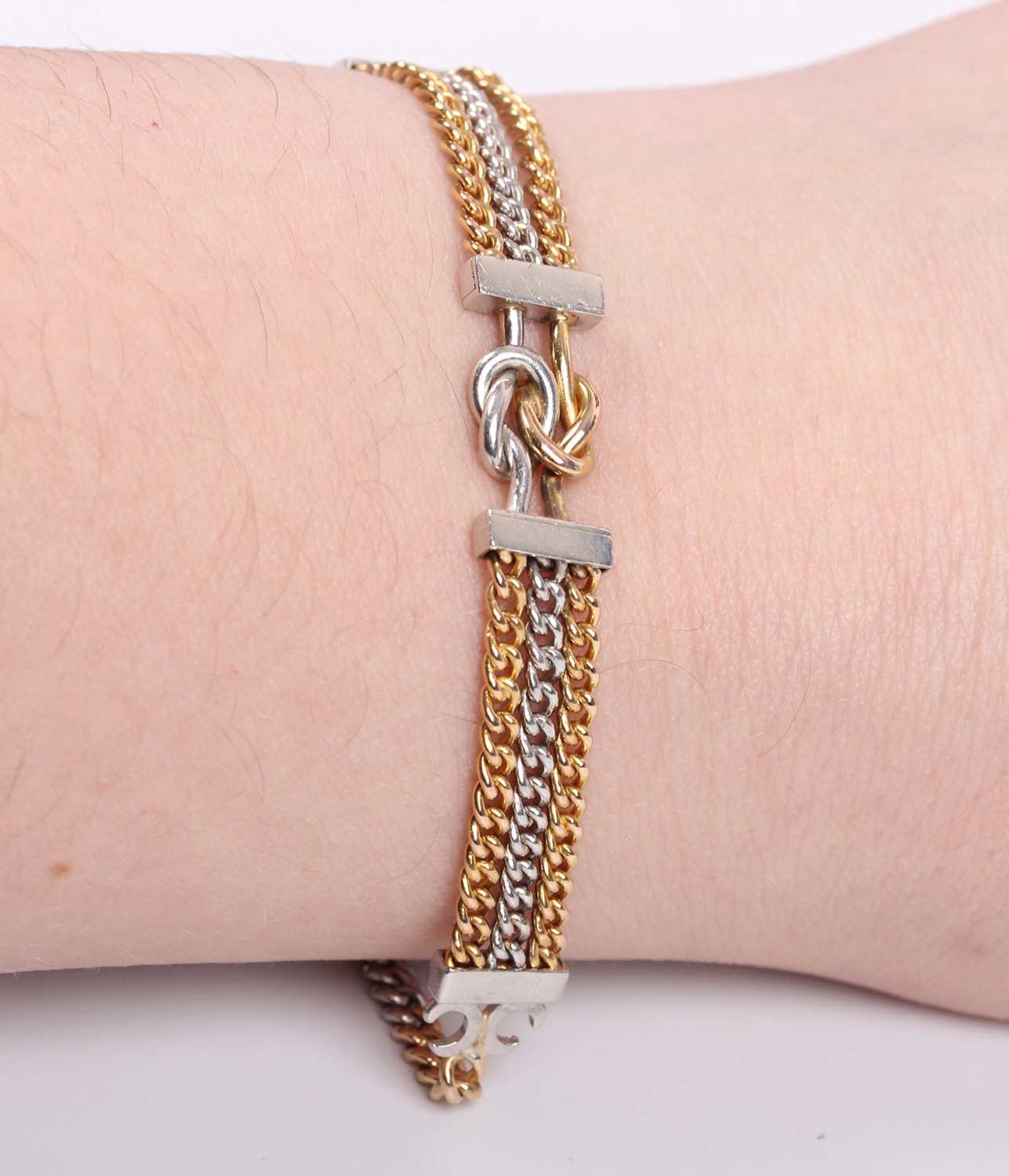 A gold and platinum bracelet, the front in a three row curblink design with a central knot shaped - Image 2 of 2
