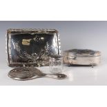 A George V matched silver four-piece dressing table set, each piece embossed with lily-of-the-