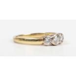 An 18ct gold and diamond three stone ring, collet set with a row of circular cut diamonds, Sheffield