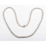 An 18ct white gold and diamond collar necklace, claw set with a row of graduated circular cut