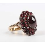 A gold, silver set and carbuncle garnet cluster ring, mounted with the principal carbuncle garnet at