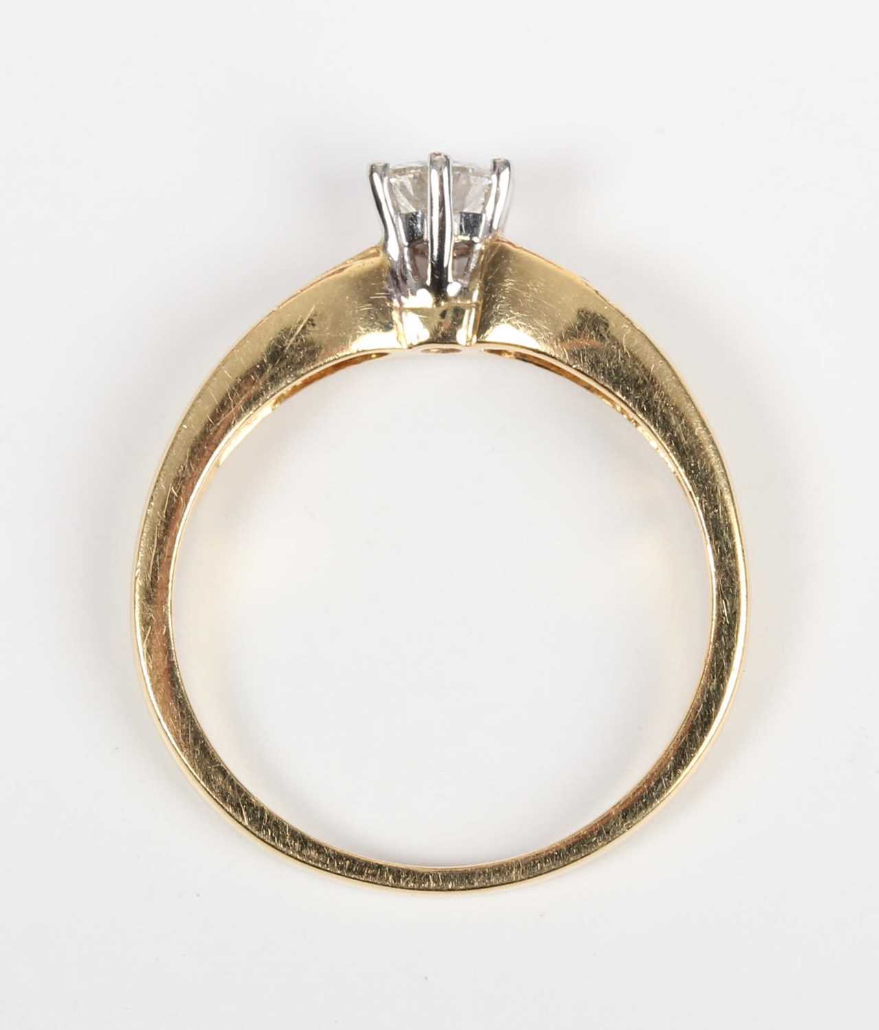 A gold and diamond ring, claw set with the principal circular cut diamond between diamond four stone - Image 4 of 5