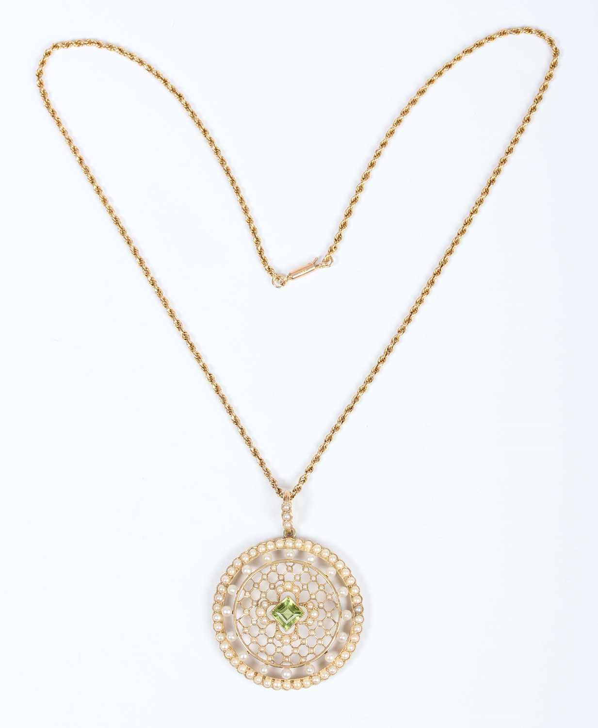 An Edwardian gold, peridot and seed pearl circular pendant of openwork design, mounted with the - Image 2 of 5