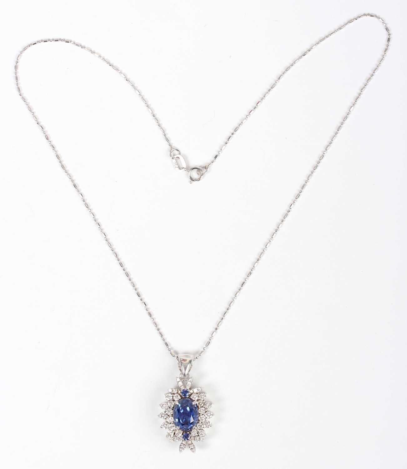 A white gold, sapphire and diamond cluster pendant, claw set with the principal oval cut sapphire - Image 2 of 3