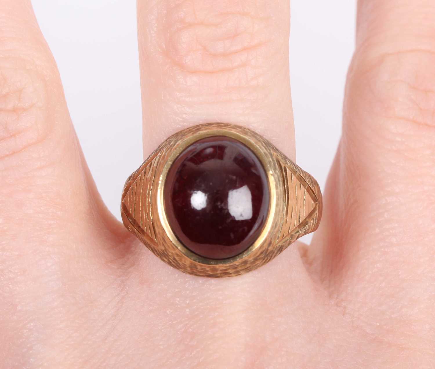 A 9ct gold and carbuncle garnet ring, mounted with an oval carbuncle garnet between textured - Image 5 of 5