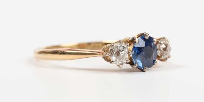 A gold, platinum, sapphire and diamond ring, claw set with a circular cut sapphire between two old