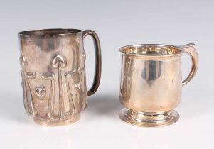 A late Victorian Arts and Crafts silver christening mug, the cylindrical body decorated in relief