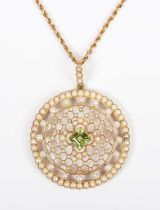 An Edwardian gold, peridot and seed pearl circular pendant of openwork design, mounted with the