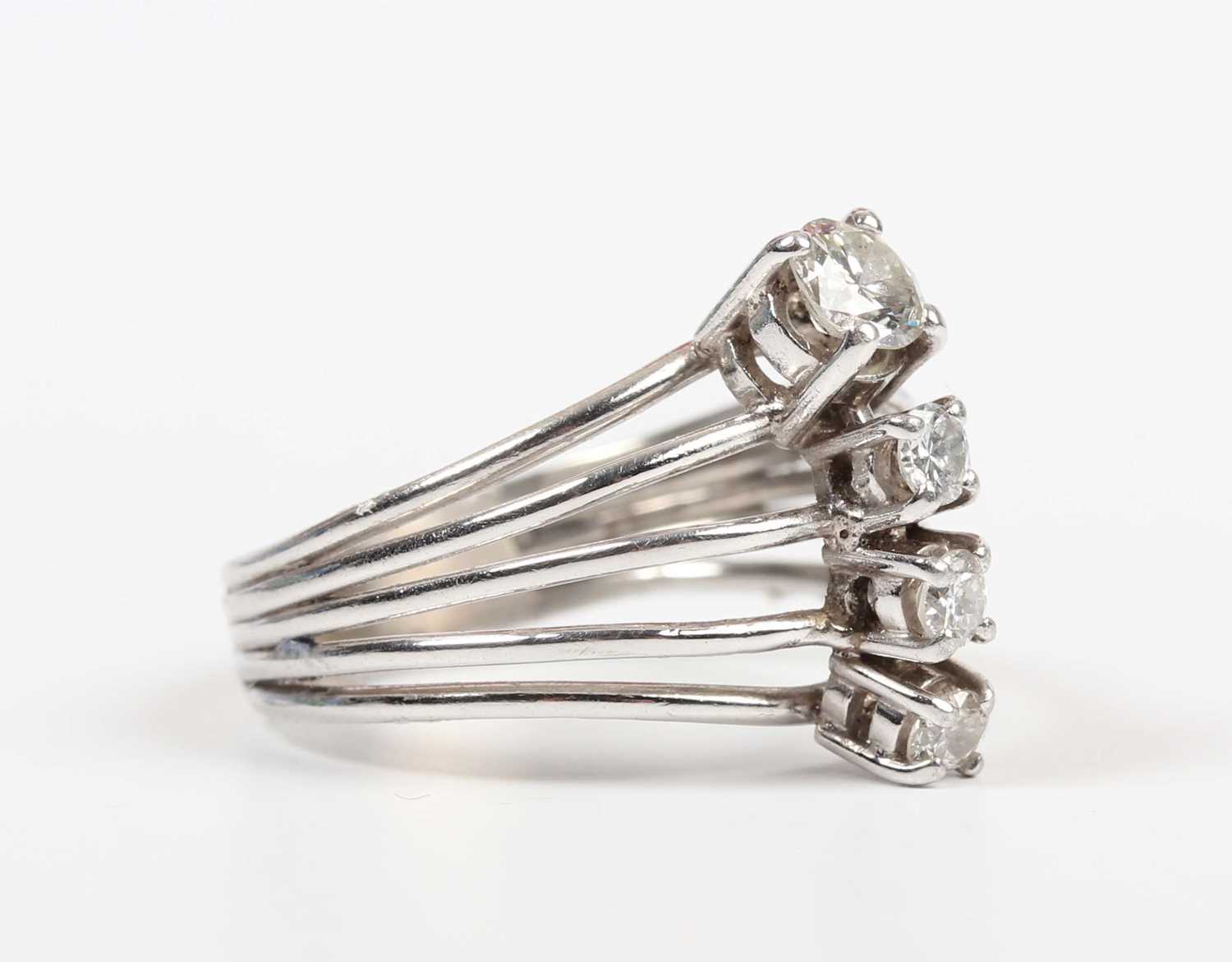 A diamond ring, claw set with a row of four circular cut diamonds between split sides, unmarked,