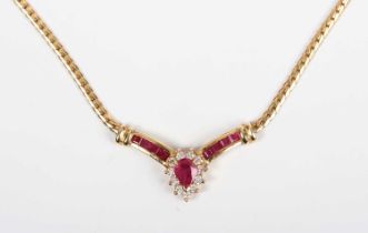 An 18ct gold, ruby and diamond necklace, the front in a ‘V’ shaped design, the principal pear shaped