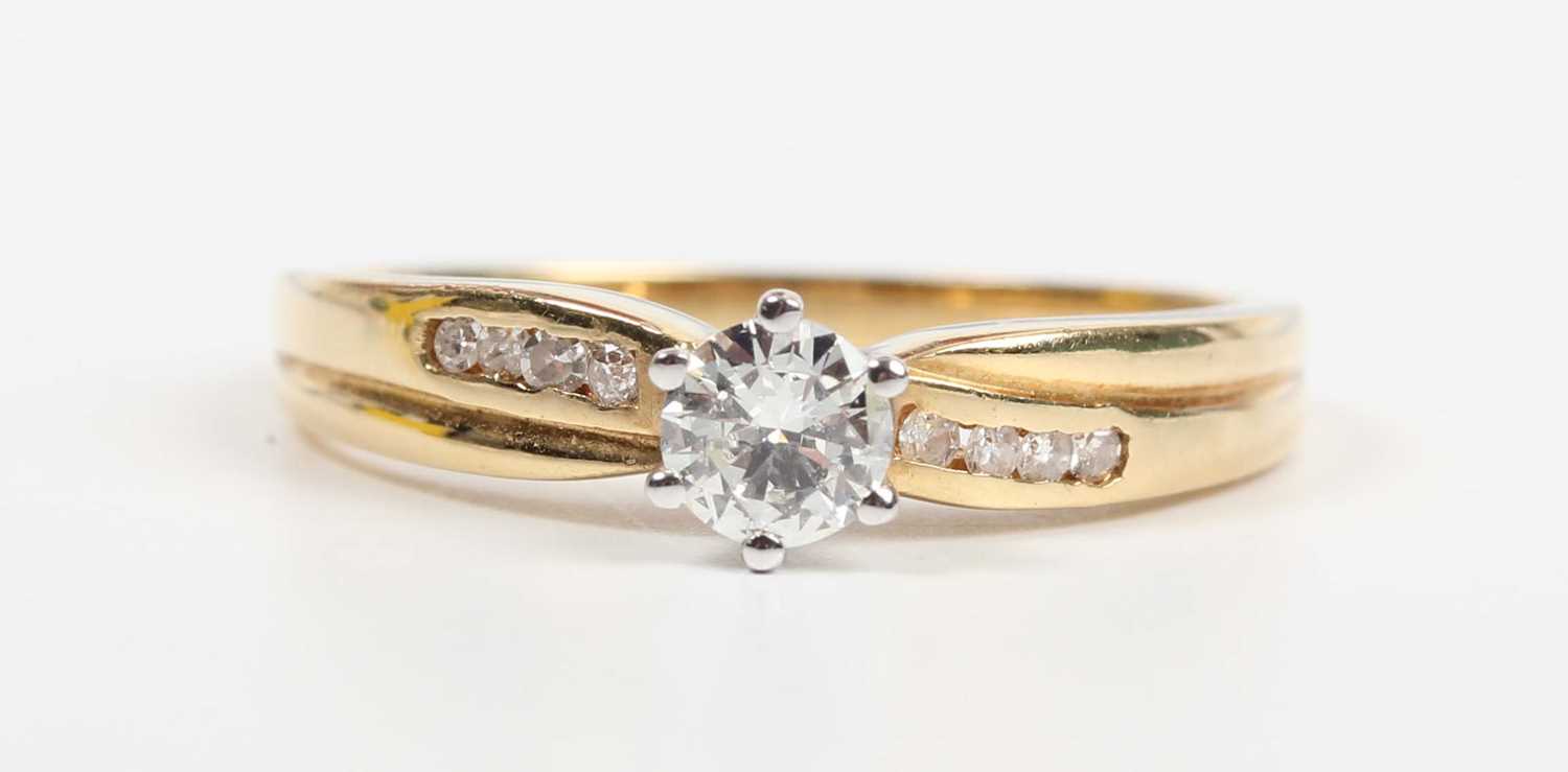 A gold and diamond ring, claw set with the principal circular cut diamond between diamond four stone - Image 2 of 5