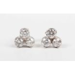 A pair of white gold and diamond earstuds, each mounted with three circular cut diamonds in a