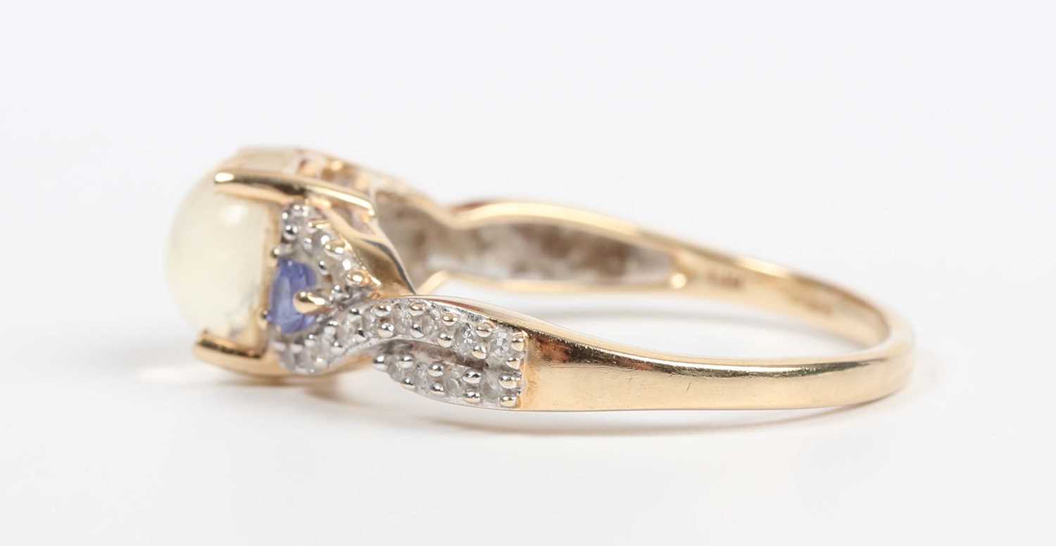 A 14ct gold ring, mounted with a central cabochon pale yellow opal between diamond and pale blue gem - Image 3 of 5