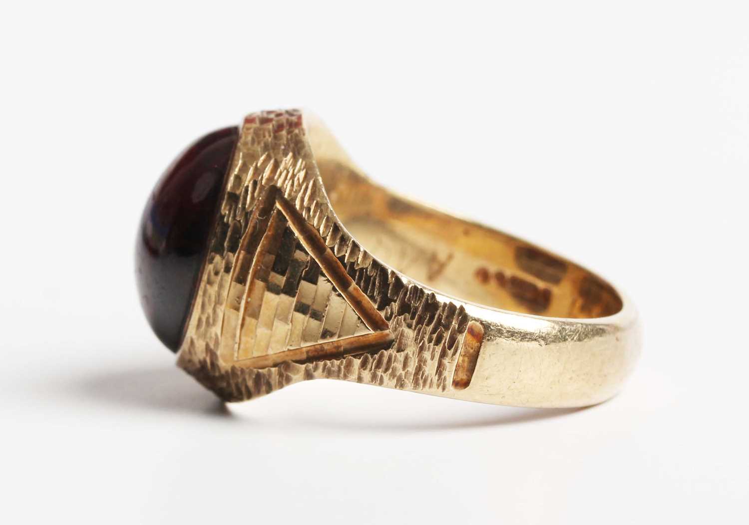 A 9ct gold and carbuncle garnet ring, mounted with an oval carbuncle garnet between textured - Image 3 of 5