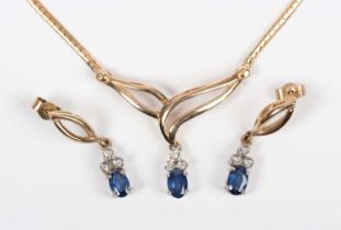 A 9ct two colour gold, sapphire and diamond necklace, the front mounted with an oval cut sapphire