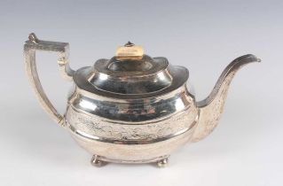 A George III silver teapot of cushion form, engraved with a band of fruiting vines, on ball feet,
