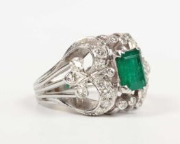 An emerald and diamond cocktail ring, claw set with the rectangular step cut emerald between
