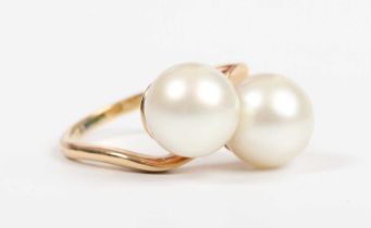 A gold ring, mounted with two cultured pearls in a crossover design, detailed ‘18K’, weight 7.4g,