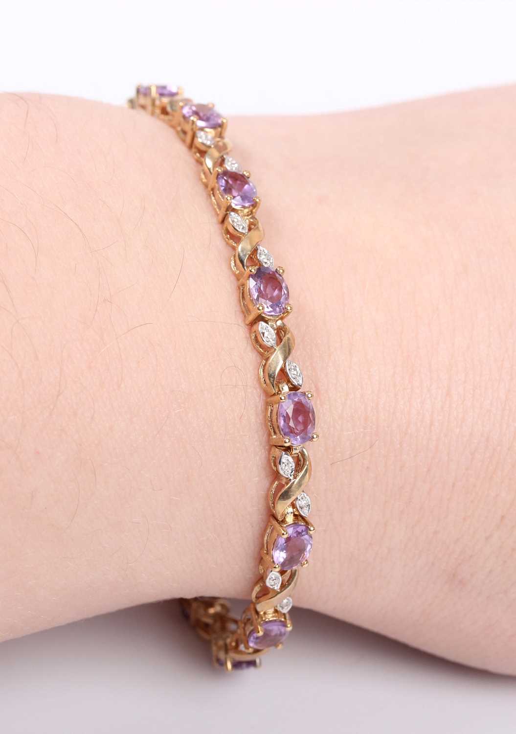 A gold, amethyst and diamond bracelet, claw set with a row of oval cut amethysts alternating with - Image 3 of 3