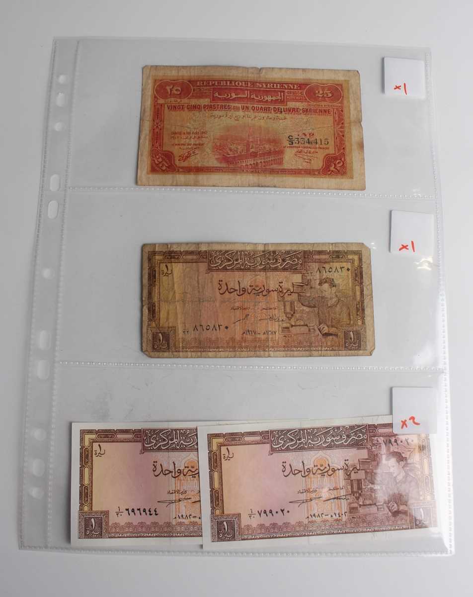 A collection of approximately fifty mid to late 20th century Syrian banknotes, within an album.