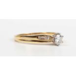 A gold and diamond ring, claw set with the principal circular cut diamond between diamond four stone