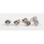 A pair of diamond single stone earstuds, each collet set with a circular cut diamond, unmarked, each