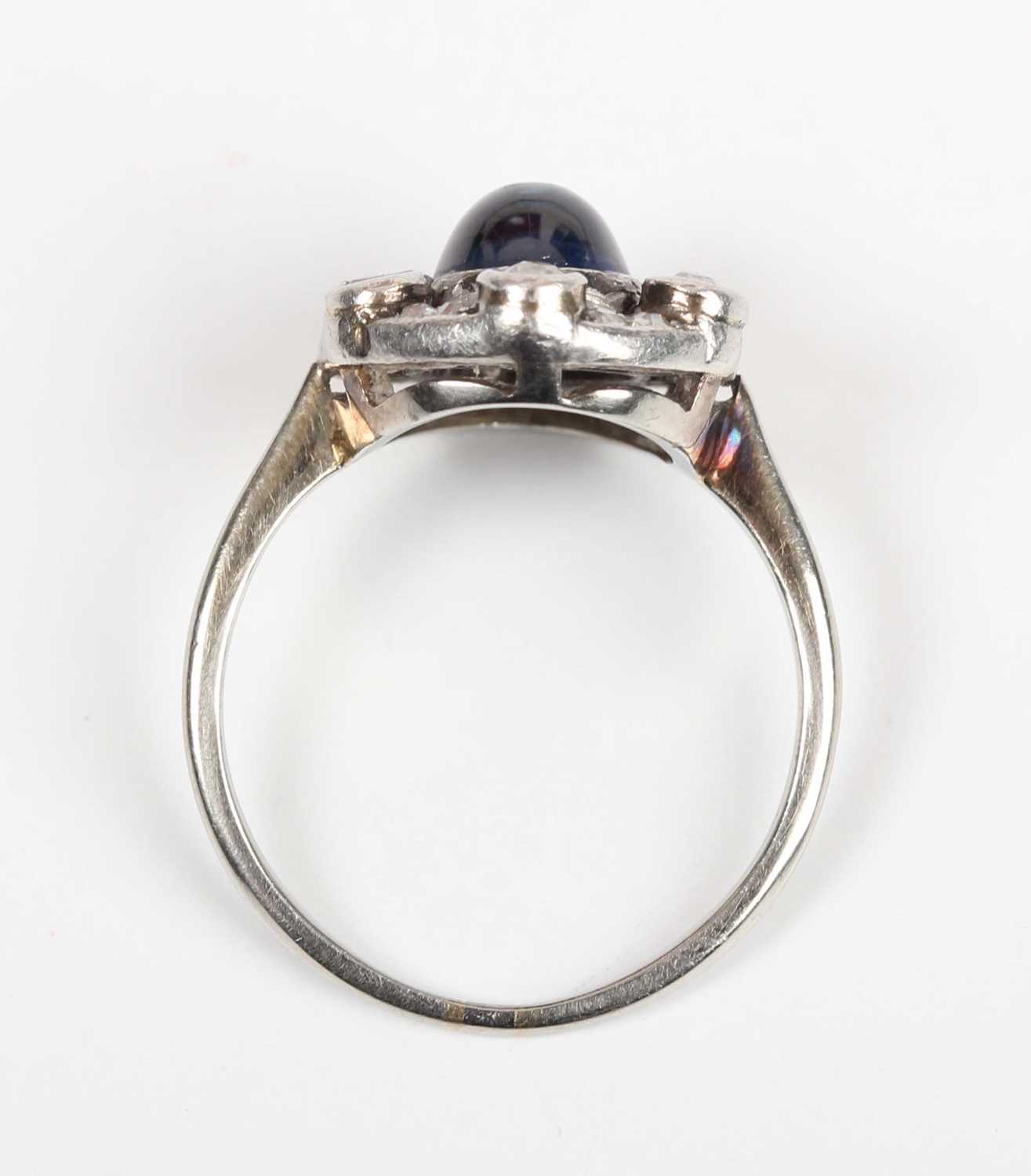 A cabochon sapphire and diamond ring, mounted with the oval cabochon sapphire within an openwork - Image 4 of 5