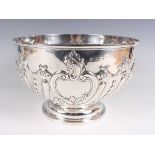 A late Victorian silver circular punch bowl, the front embossed with a foliate and 'C' scroll vacant