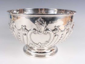 A late Victorian silver circular punch bowl, the front embossed with a foliate and 'C' scroll vacant