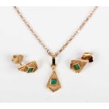 A gold pendant collet set with a cut cornered square step cut emerald to the centre, detailed ‘18K’,