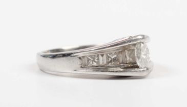 A platinum and diamond ring, mounted with the principal marquise shaped diamond in a raised