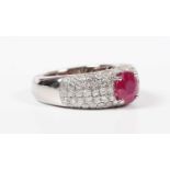 A white gold, treated ruby and diamond ring, claw set with the circular cut treated ruby to the