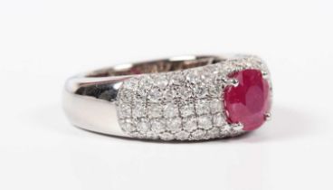 A white gold, treated ruby and diamond ring, claw set with the circular cut treated ruby to the