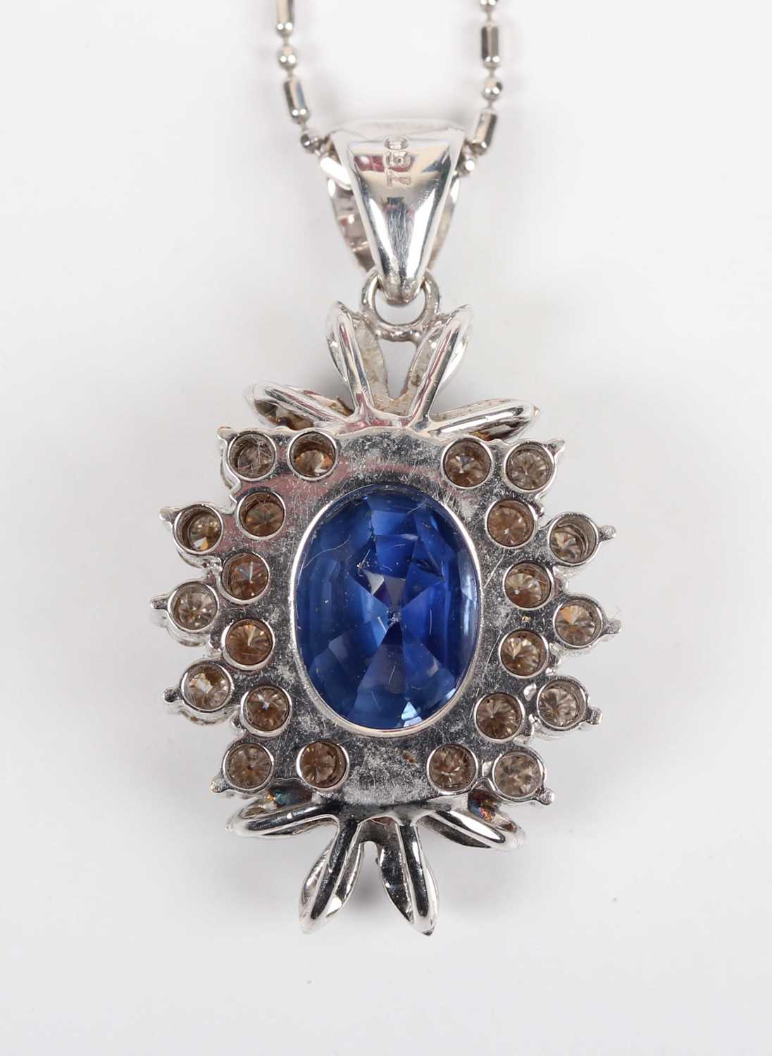 A white gold, sapphire and diamond cluster pendant, claw set with the principal oval cut sapphire - Image 3 of 3