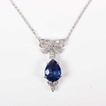 A white gold, sapphire and diamond pendant necklace, the front designed as a tied bow, with a pear