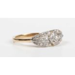 A gold and diamond ring in an oval panel shaped design, mounted with circular cut diamonds,