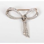A gold backed and diamond brooch designed as a tied bow, mounted with cushion cut diamonds,
