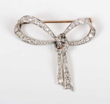 A gold backed and diamond brooch designed as a tied bow, mounted with cushion cut diamonds,