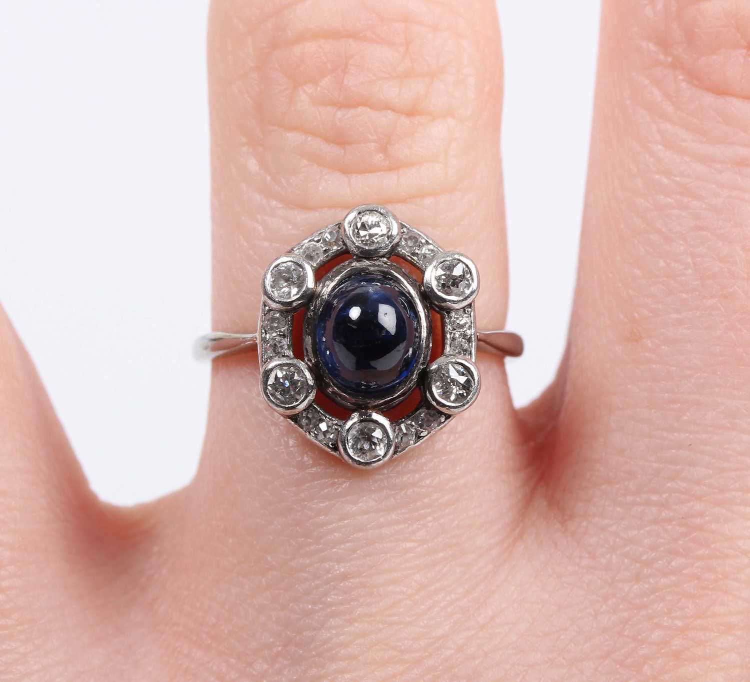 A cabochon sapphire and diamond ring, mounted with the oval cabochon sapphire within an openwork - Image 5 of 5