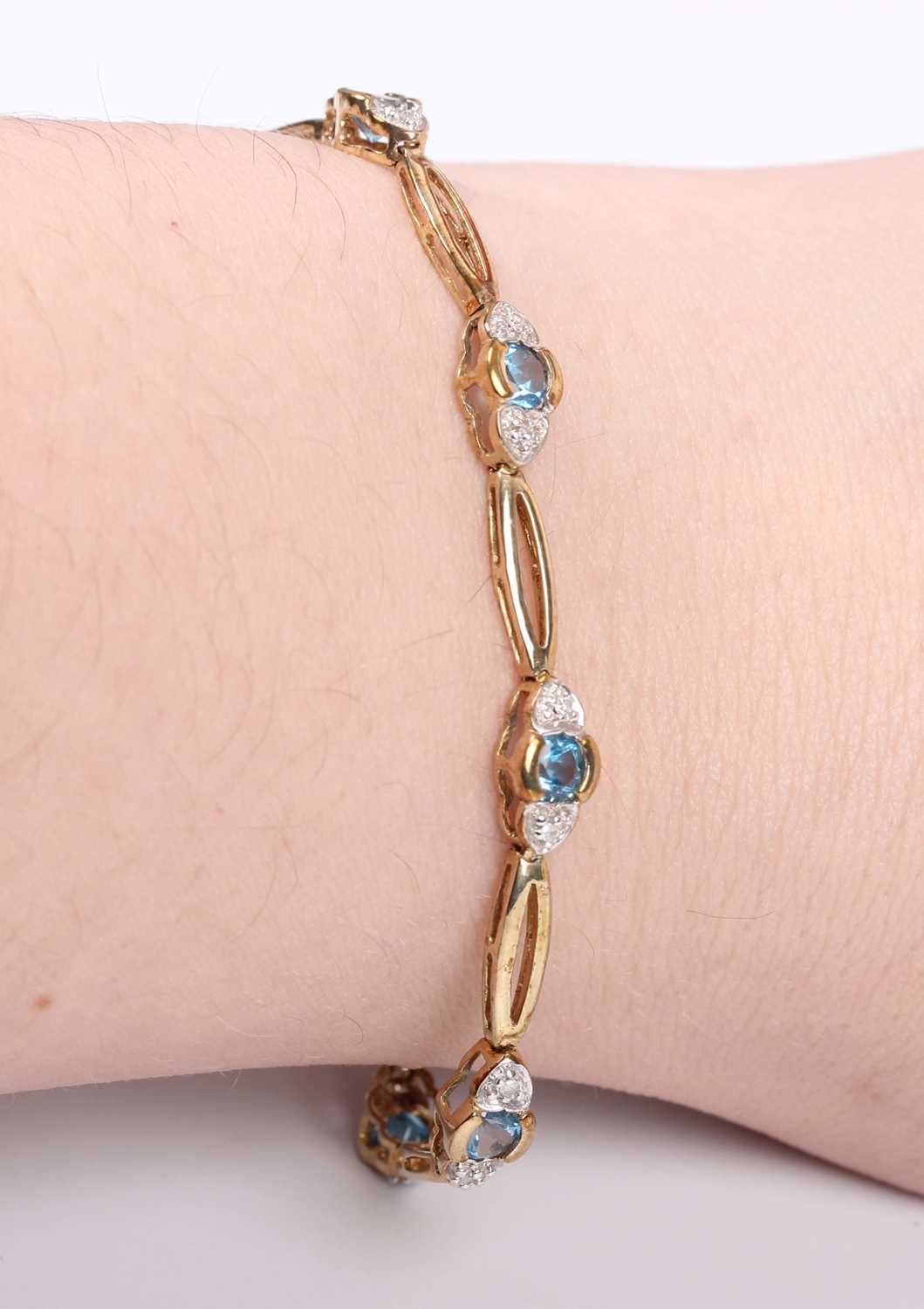 A 9ct gold, diamond and treated blue topaz bracelet, mounted with a row of circular cut treated blue - Image 3 of 3