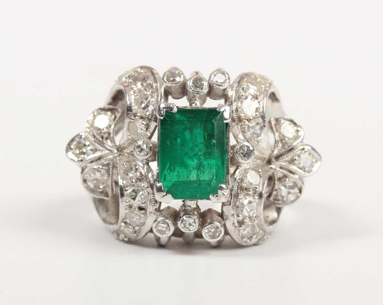 An emerald and diamond cocktail ring, claw set with the rectangular step cut emerald between - Image 2 of 5