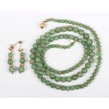 A single row necklace of graduated jade beads, on a gold ridged spherical clasp, detailed ‘375’,