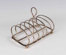 A George IV silver six-division toast rack with central loop handle, on ball feet, Sheffield 1827,