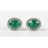 A pair of white gold, emerald and diamond oval cluster earstuds, each claw set with an oval cut