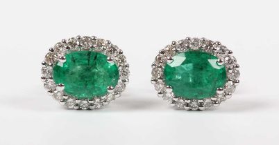 A pair of white gold, emerald and diamond oval cluster earstuds, each claw set with an oval cut