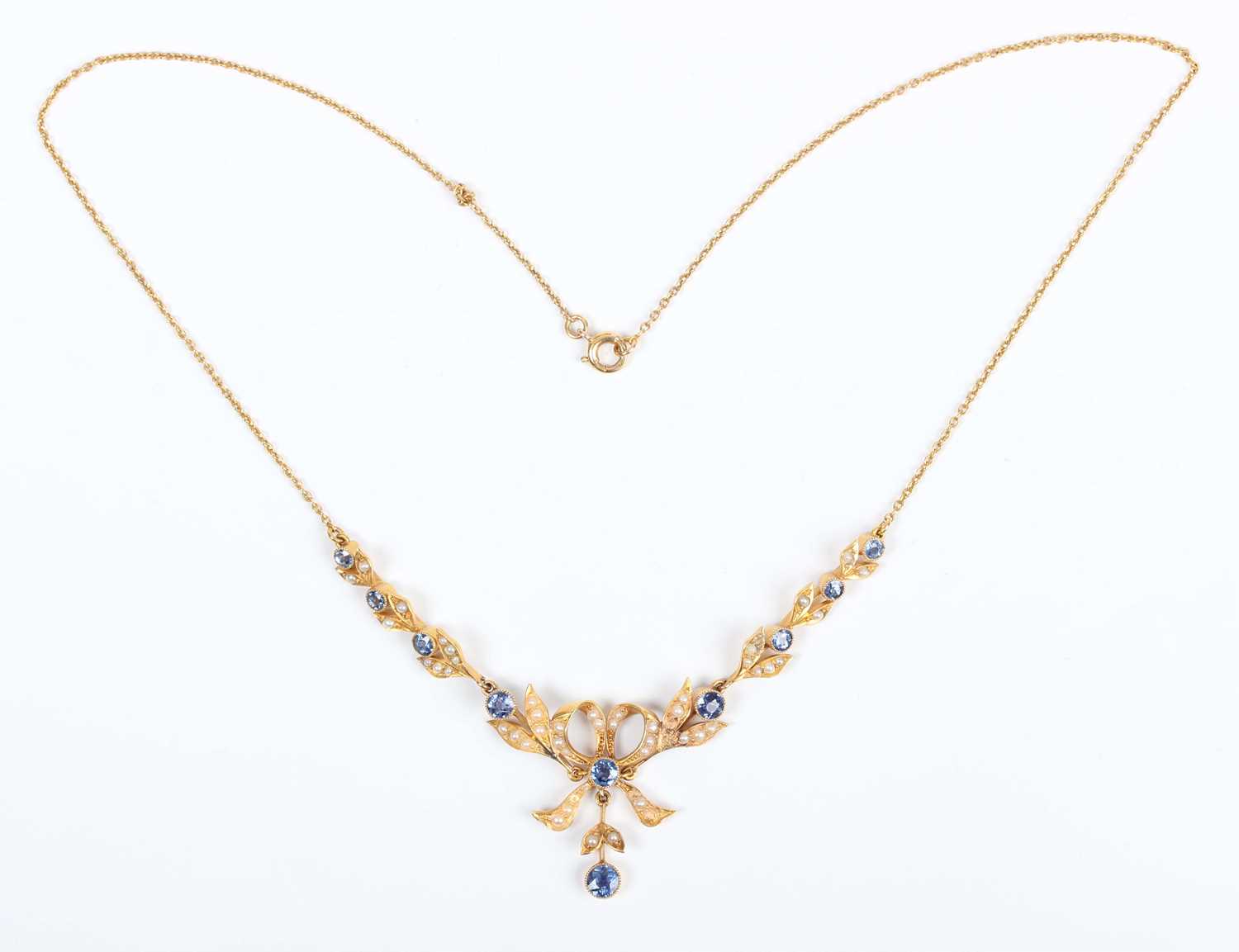 An Edwardian gold, sapphire and seed pearl necklace, the front designed as a tied bow with foliate - Image 2 of 3