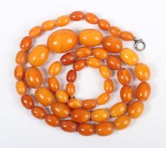 A single row necklace of fifty-one graduated oval opaque and semitranslucent mottled butterscotch