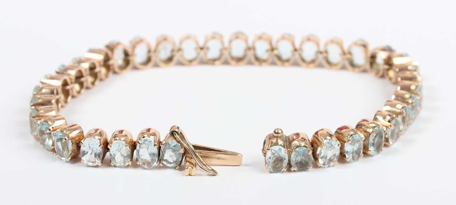 A gold and aquamarine bracelet, claw set with a row of oval cut aquamarines, on a snap clasp, - Image 2 of 3